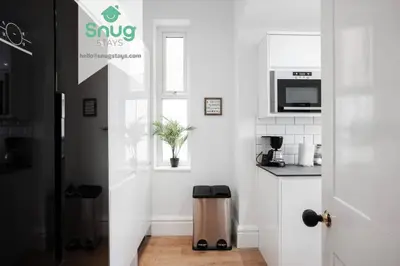 a white kitchen with a window and a trash can at Fairfield house - 4 bedroom, 8 beds, free Wi-Fi, free parking in Liverpool