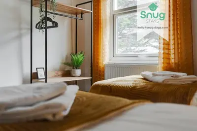 two beds in a room with a window and towels at Fairfield house - 4 bedroom, 8 beds, free Wi-Fi, free parking in Liverpool