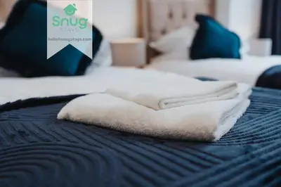 a pile of white towels sitting on a bed at Fairfield house - 4 bedroom, 8 beds, free Wi-Fi, free parking in Liverpool