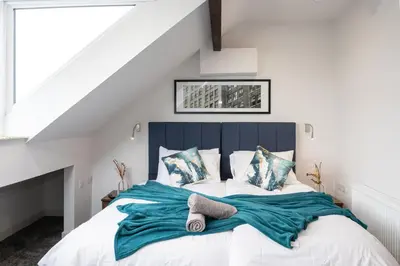 a bedroom with a blue and white bed with pillows at Morecambe Bay Free Parking By Beach Front Sea View in Morecambe