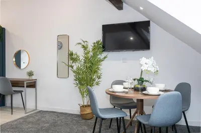 a dining room with a table and chairs and a tv at Morecambe Bay Free Parking By Beach Front Sea View in Morecambe