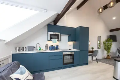 a kitchen with blue cabinets in a loft at Morecambe Bay Free Parking By Beach Front Sea View in Morecambe