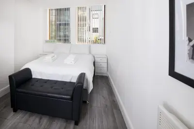 a small bedroom with a bed and a chair at GuestReady - Monochromatic Retreat in Liverpool