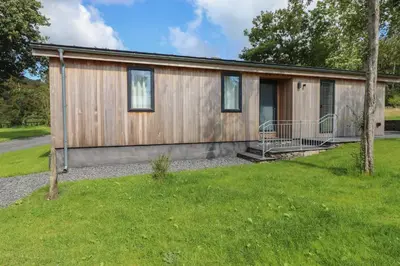a small wooden house with a green yard at The Beeches in Ulverston