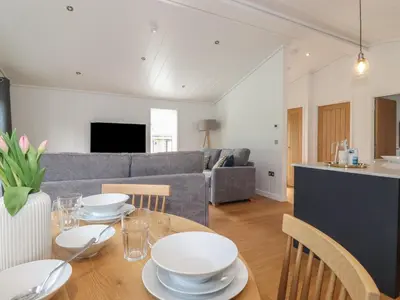 a living room with a table with white dishes on it at The Beeches in Ulverston