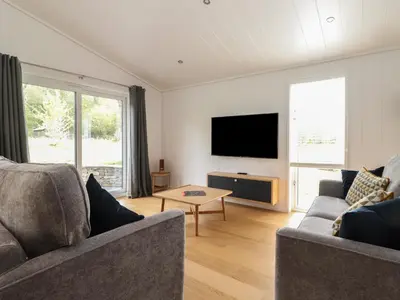 a living room with two couches and a flat screen tv at The Beeches in Ulverston