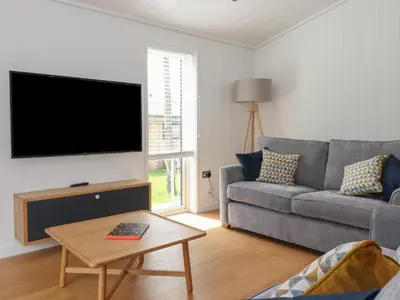 a living room with a couch and a flat screen tv at The Brambles in Ulverston