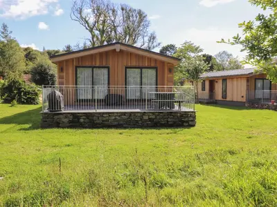 a small house with a deck on a grass field at The Brambles in Ulverston