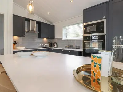a kitchen with a white counter top and black cabinets at Millstream Ridge in Ulverston