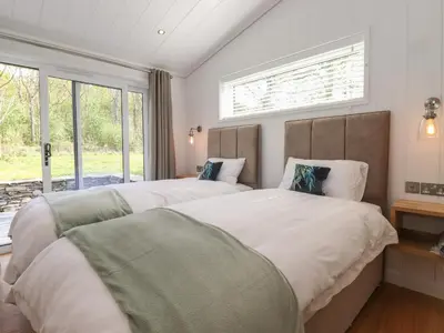 two beds in a bedroom with a window at Corning Mill View in Ulverston