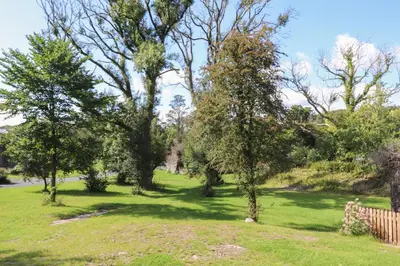 a park with trees and grass and a fence at Ash Thwaite in Ulverston