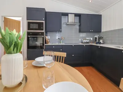 a kitchen with a table with a vase with wine glasses at Hawthorn Croft in Ulverston