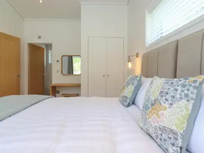 a bedroom with a large white bed with two pillows at Hawthorn Croft in Ulverston
