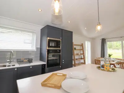 a kitchen with black cabinets and a white counter top at The Burrow in Ulverston