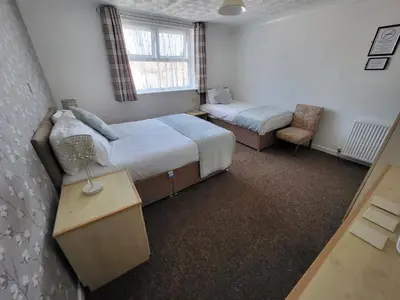 a small bedroom with two beds and a chair at The Lumada in Blackpool