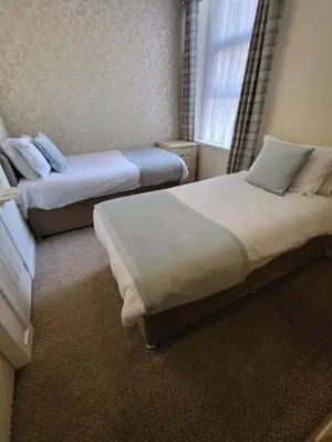 two beds in a small room with a window at The Lumada in Blackpool