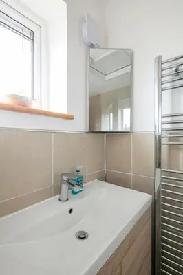 a white bathroom with a sink and a mirror at Double Room l Large TV l Great Transport Links in Bolton