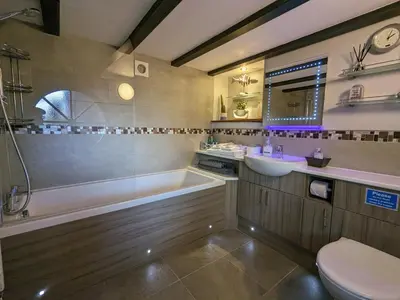 a bathroom with a tub and a toilet and a sink at The Dairy at Brackenthwaite Farm in Carnforth