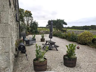 a patio with a picnic table and an umbrella at The Dairy at Brackenthwaite Farm in Carnforth