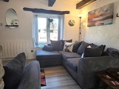 a living room with a couch and a window at The Coach House at Brackenthwaite Farm in Carnforth