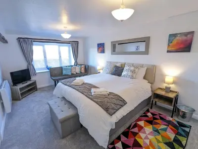 a bedroom with a large bed and a television at The Coach House at Brackenthwaite Farm in Carnforth