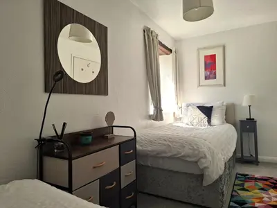 a bedroom with a bed and a dresser with a mirror at The Coach House at Brackenthwaite Farm in Carnforth