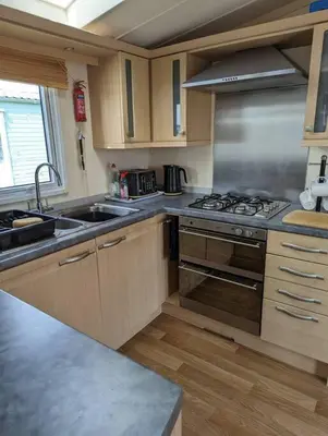 a kitchen with a stove and a sink at 6 berth holiday home on Ocean Edge near Morecambe in Heysham