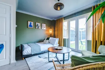 a bedroom with a bed and a table in a room at Newly Refurbished 3 Double Bedroom Knowsley Liverpool Townhouse in Knowsley