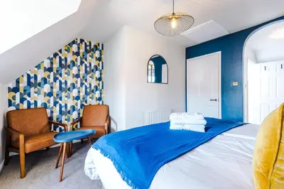a bedroom with a bed and a chair at Newly Refurbished 3 Double Bedroom Knowsley Liverpool Townhouse in Knowsley