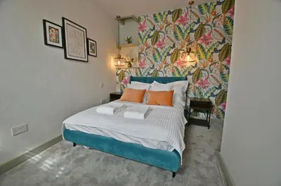 a bedroom with a blue bed with orange pillows at Quirky cottage set in Clitheroe in Clitheroe