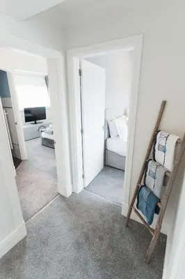 a hallway with a room with a bed and a chair at Birkby Lodge Escape in Lytham St Annes