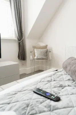 a remote control sitting on a bed in a bedroom at Birkby Lodge Escape in Lytham St Annes