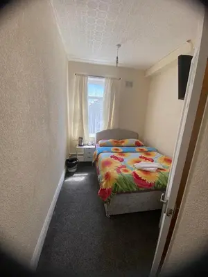 a small bedroom with a bed and a window at Crosby Hotel in Blackpool