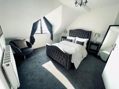 a bedroom with a bed and a chair and a mirror at Baltic Dockside Apartment, Free Parking in Liverpool