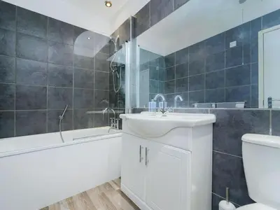 a bathroom with a sink and a tub and a toilet at Baltic Dockside Apartment, Free Parking in Liverpool