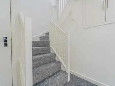 a staircase in a home with white walls and gray carpet at Baltic Dockside Apartment, Free Parking in Liverpool