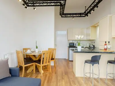 a kitchen and living room with a table and chairs at Baltic Dockside Apartment, Free Parking in Liverpool