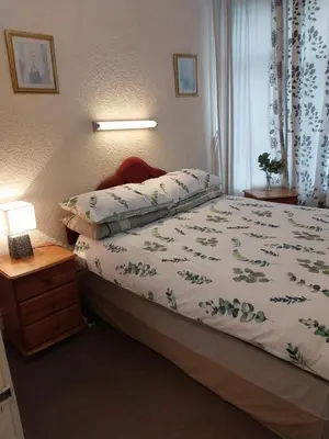 a bedroom with a bed and a table with a lamp at Lynwood Hotel & Spa in Blackpool