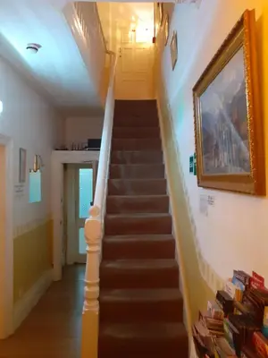 a staircase in a house with a painting on the wall at Lynwood Hotel & Spa in Blackpool