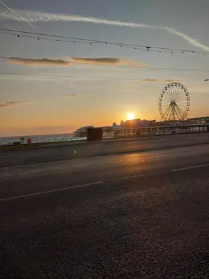 a ferris wheel and a road with the sunset at Lynwood Hotel & Spa in Blackpool
