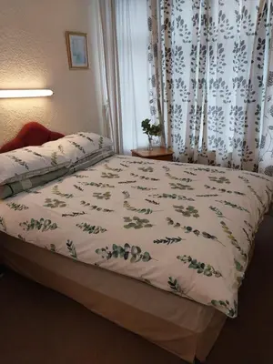 a bedroom with a bed with a floral bedspread at Lynwood Hotel & Spa in Blackpool