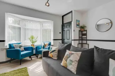 a living room with a gray couch and blue chairs at 10Min Walk to Stadium SofaBed WM & Dishwasher in Liverpool