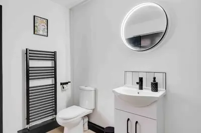 a white bathroom with a toilet and a mirror at 10Min Walk to Stadium SofaBed WM & Dishwasher in Liverpool