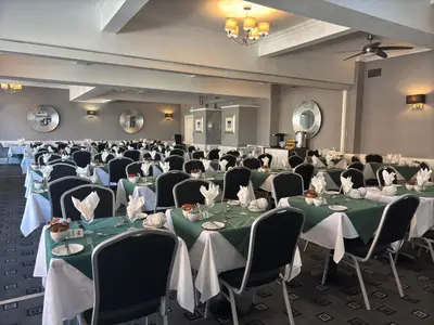 a banquet room with tables and chairs with green tablecloths at The Royal Boston Hotel by Compass Hospitality in Blackpool
