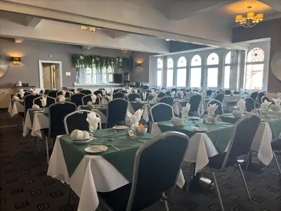 a banquet hall with green tables and chairs at The Royal Boston Hotel by Compass Hospitality in Blackpool