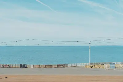 a beach with a fence and the ocean at The Royal Boston Hotel by Compass Hospitality in Blackpool
