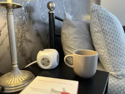 a alarm clock and a coffee cup on a table at Modernised central Wigan townhouse sleeps up to 6 in Wigan