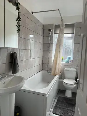 a bathroom with a tub and a toilet and a sink at Modernised central Wigan townhouse sleeps up to 6 in Wigan