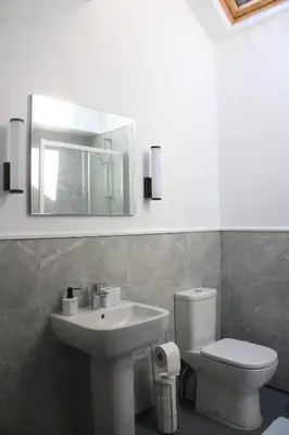 a bathroom with a sink and a toilet and a mirror at Fenwick Sunrise Hotel in Liverpool
