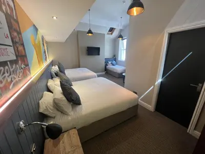 a bedroom with a bed and a couch in it at Fenwick Sunrise Hotel in Liverpool